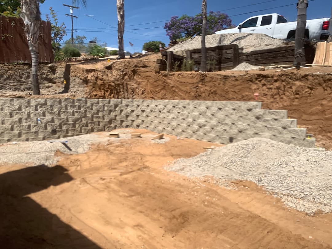 Excavation work preparing yard for retaining wall and hardscape build